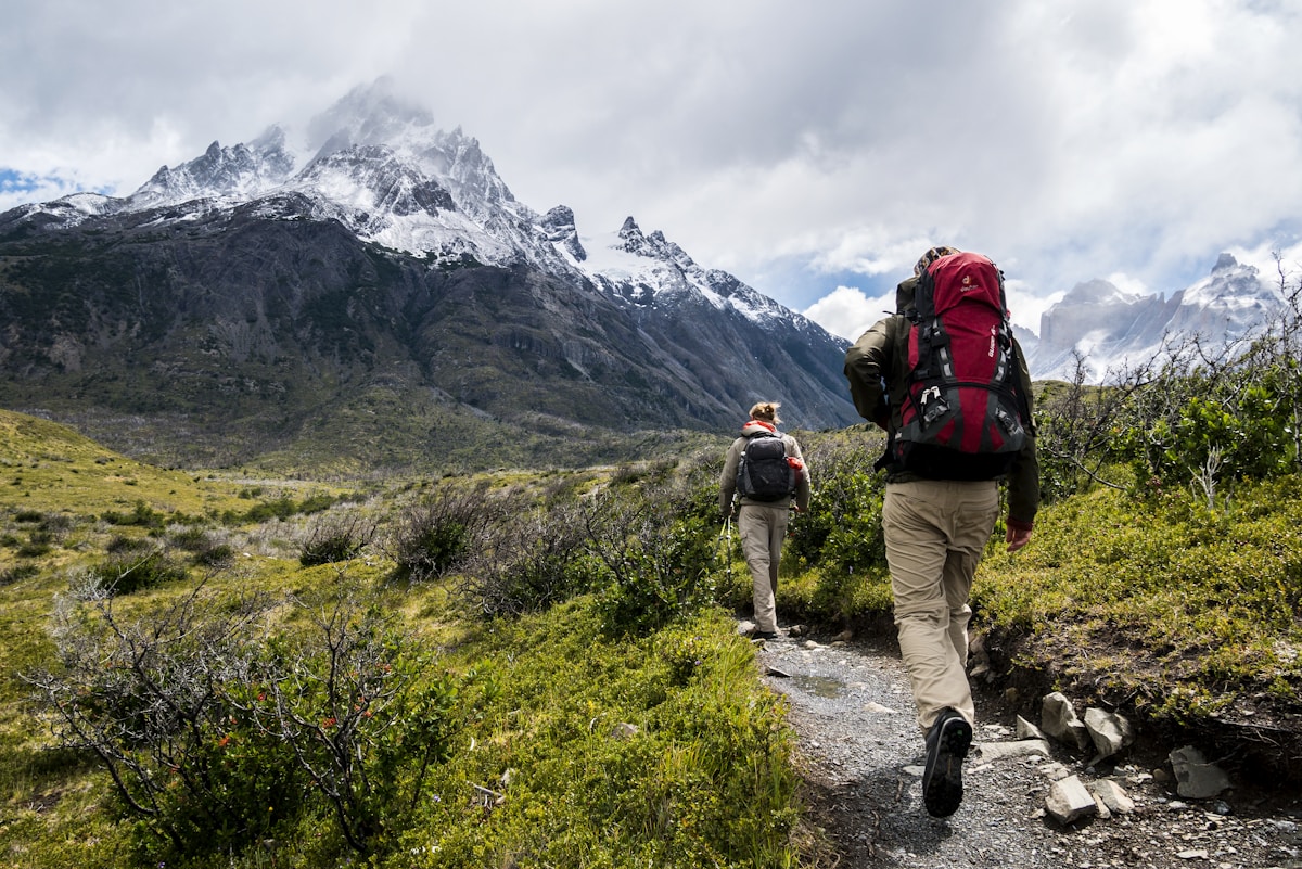 Trail runner wearing a cap on exposed mountain singletrack at high elevation